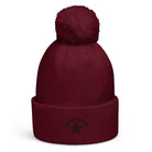 Pom pom beanie in bordeaux met een grote pompon en zwarte opdruk voor extra stijl en warmte.