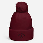 Pom pom beanie in bordeaux met een zachte pompon bovenop en geborduurde tekst aan de voorkant.