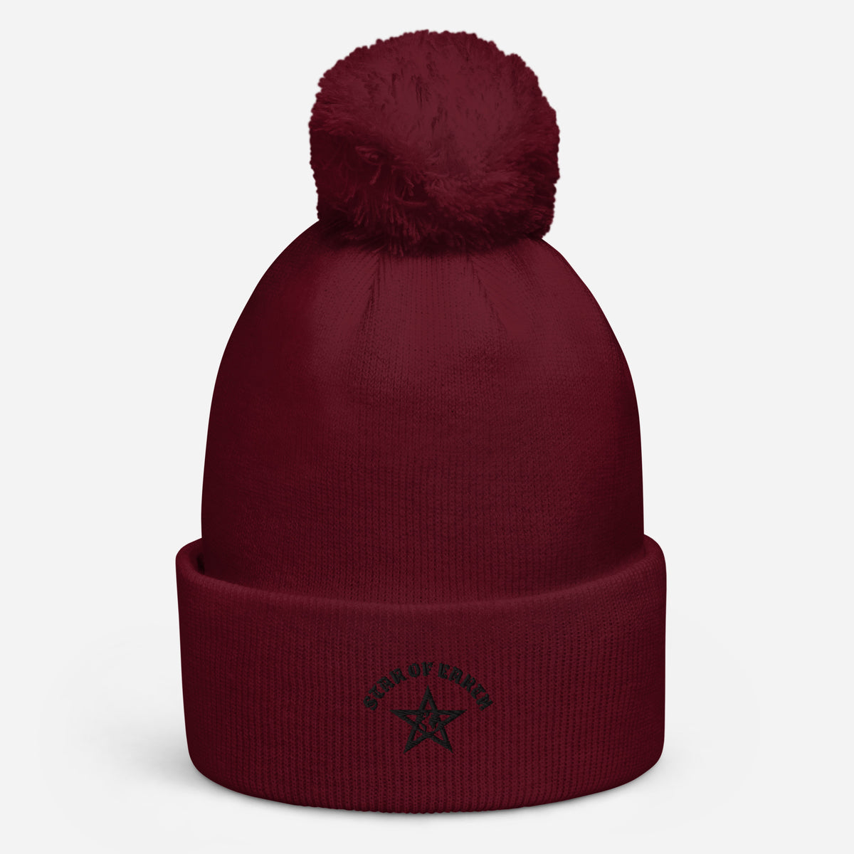 Pom pom beanie in bordeaux met een zachte pompon bovenop en geborduurde tekst aan de voorkant.